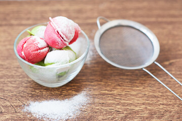 Multicolored cookies in the form of Nuts with filled cream in a glass transparent vase on table on a light background