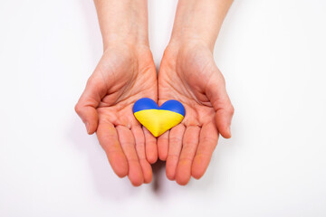 Heart flag of Ukraine in human hands. No war, peace for Ukraine concept.