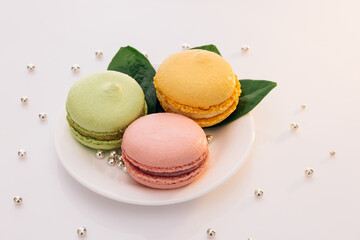 Multicolor macarons , french macaroon, greedy pastry. French dessert sweets colored macaroons cookies arranged on a while plate on white background