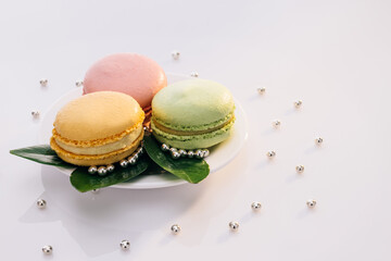 Macarons on white reflective glass, sweet tasty desserts. Multicolor macarons , french macaroon, greedy pastry. French dessert sweets colored macaroons cookies arranged on a while plate