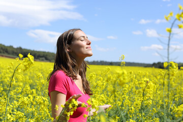 Naklejka na ściany i meble Happy woman breathing fresh air in the middle of a field
