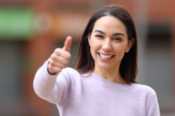 Happy woman with perfect teeth gesturing thumb up