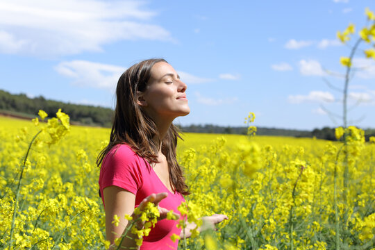 Happy woman breathing fresh air in the middle of a field