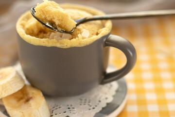 selective focus. homemade Portioned Banana bread mugcake in small mugs. Easy sweet baking in the microwave idea, With fresh bananas, nuts. Muffin with banana slices cooked in a mug. copy space. 