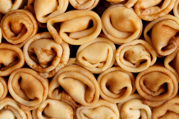 Naklejka premium Stack of crepes rolls twisted with meat. Traditional Ukrainian russian thin pancakes as background. Tasty morning breakfast or lunch. Homemade food for maslenitsa. Banner. Close up view.