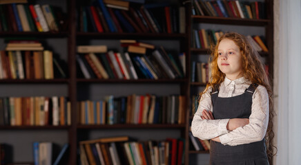 Girl in the library near the shelf with books.