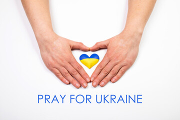 Heart flag of Ukraine in human hands. No war, peace for Ukraine concept.