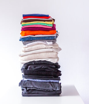 Stack of folded colorful clothes on white background.