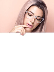 Beautiful woman with eyeglasses and pink hair looking down  at blank banner on pink background