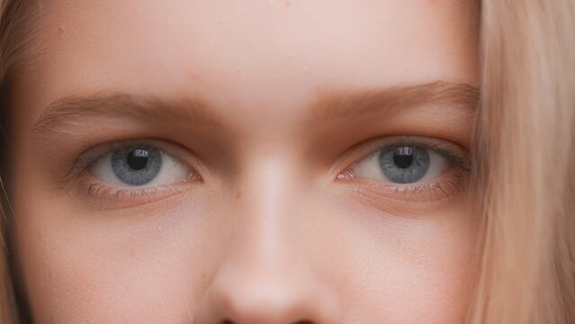 Extreme close-up shot of young blonde woman looks at the camera