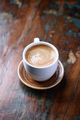 Cup of coffee on rustic wooden background. 