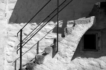 Grayscale image of stone stairs outside of a rural house