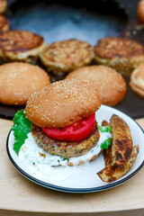Chicken burgers cooking on an outdoor grill
