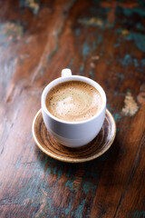 Cup of coffee on rustic wooden background.