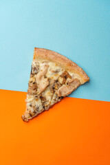 Slice of pizza with chicken fillet, mushrooms, spinach, mozzarella and gouda cheeses with creamy sauce. Blue orange background. view from above. copy space
