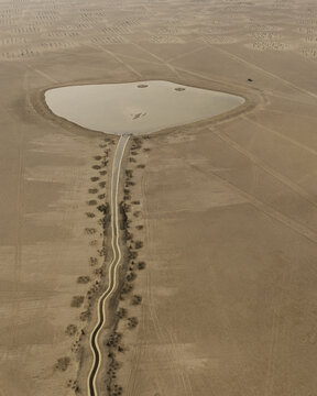 Aerial view of a desert aqueduct in a shape of a common stingray with qanat holes