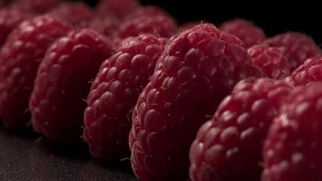 Close-up of rows of ripe raspberries. Fresh and juicy raspberries. Fruits of red raspberries close-up as a food background. 