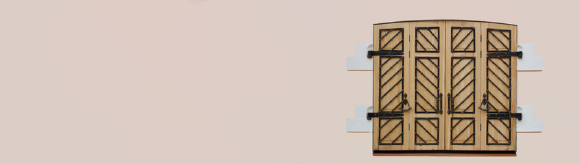 Old wooden window with shutters on pink navkground.