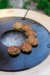 Chicken burgers cooking on an outdoor grill