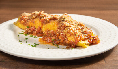 Vegan food, tofu pancake, in a white plate on wooden surface, selective focus.