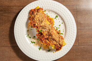 Vegan food, tofu pancake, in a white plate on wooden surface, top view.