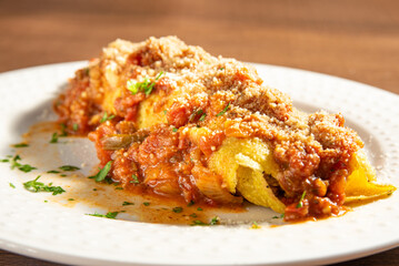 Vegan food, tofu pancake, in a white plate on wooden surface, selective focus.