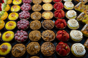 Gennevilliers, France - 03 11 2022: Artisan baker and pastry chef. Detail of mixed tartlets and cakes in a bakery