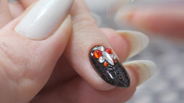 Applying a three-dimensional pattern with rhinestones and broths on the nail.