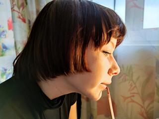 teenage girl with brown hair paints her lips