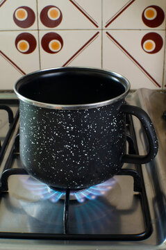 Cazo negro en fuego con gas y cocina setentera
