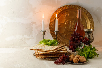 Passover background with wine bottle and matzah, burning candles and seder plate.