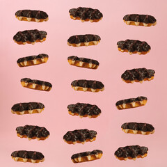 Pattern of Chocolate coated Belgian waffles falling into stack on minimal pink background.