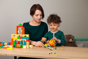 A woman plays with a child showing what a coronavirus molecule looks like on an orange with...