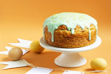 Easter cake covered with icing on a cake bowl and Easter eggs. Festive concept.