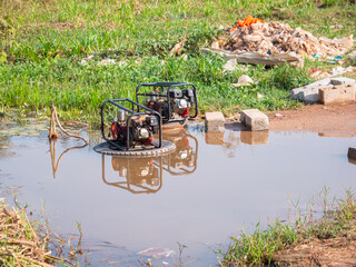 two diesel generators standing in a big puddle of water at a bike washing station in liberia