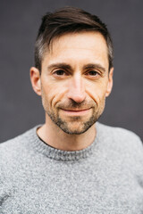 Portrait of a man in casual clothes, against a grey background