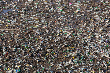 Plastic bottles in water. The river polluted with rubbish. Waste floating on the water surface. Garbage heap. Global environmental problem. Contaminated Avar Koysu river in Dagestan, Russia.
