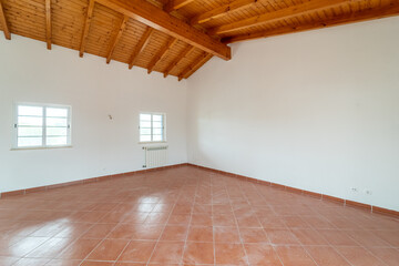 Empty room with ceramic tile flooring and wood ceiling. House interior, wide bedroom space. Newly recently painted new apartment or house. Real state and property management