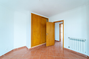 Empty room with ceramic tile flooring. House interior, wide bedroom space with wardrob. Newly recently painted new apartment or house. Real state and property management