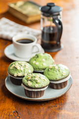 Sweet muffins with pistachio icing. Sweet dessert on wooden table.