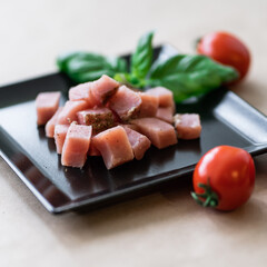 salted meat on a plate with basil and tomatoes