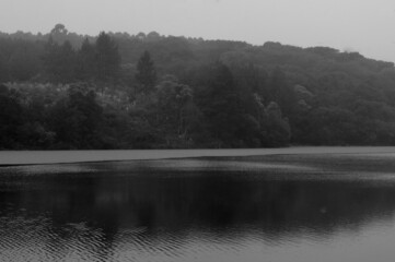 Black and white photograph of the lake on a cloudy and rainy day 