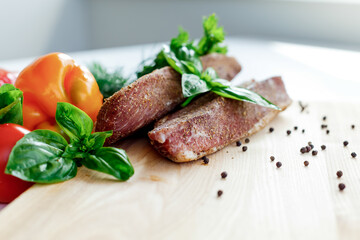 meat on a wooden board with vegetables