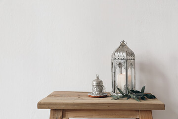 Ramadan Kareem still life. Ornamental lantern with burning candle and Turkish silver cup with tea...