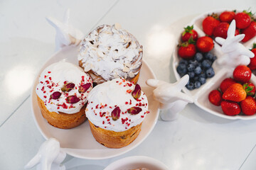 decorated panettones and cruffins on serving plates with rabbits. easter cakes. 