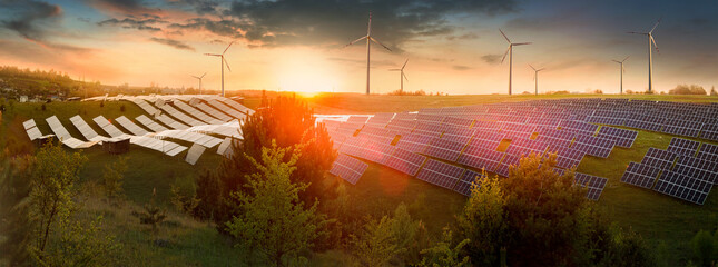 field of solar panels and wind generators at sunset, glare and reflections, bokeh - obrazy, fototapety, plakaty