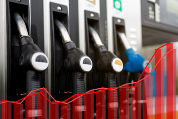 Close up of a gas dispenser at a gas station. Statistical graph in red color inserted in the image....
