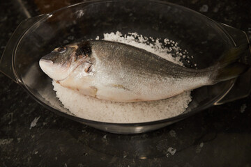 Sea bream in a bowl with salt