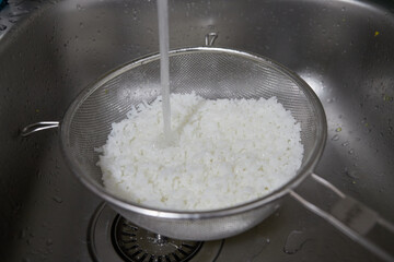 Cold water tap cooling the freshly cooked rice