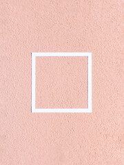 Fototapeta premium Facade of coarse fraction with grain texture painted in yellow/pink color with white frame. Minimal concept. Copy space.